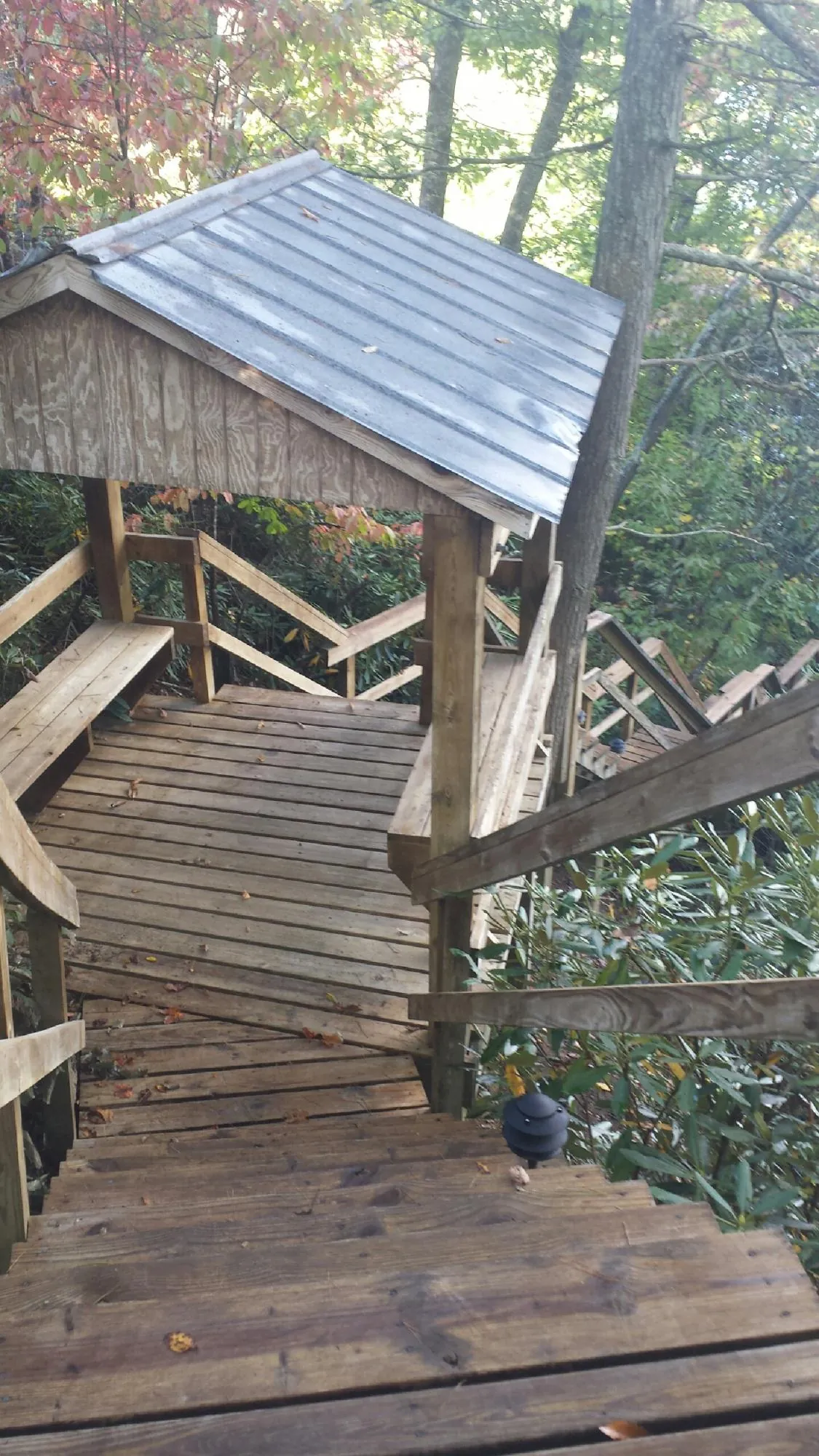 Metal roofed shelter over wooden steps on a wooded walkway — Skylight Repair & Installation work by our crew in Bound Brook