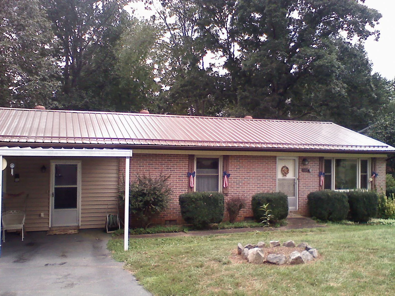 Bronze metal roof and carport on a brick ranch home — Roof Repair work by our crew in Bound Brook